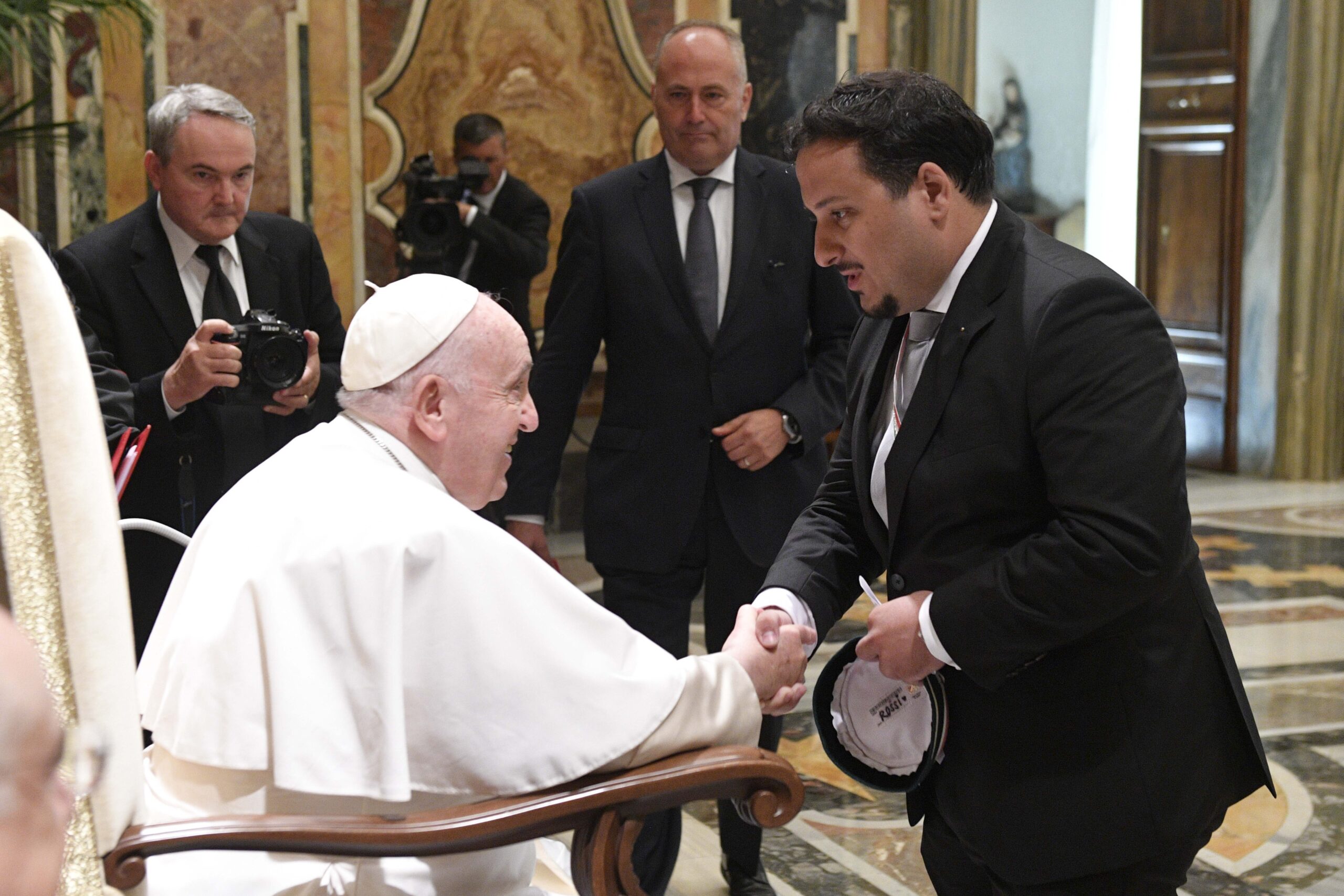A member of the Society of Swiss Students greets Pope Francis during an audience in the Clementine Hall of the Apostolic Palace at the Vatican Sept. 12, 2022. (CNS photo/Vatican Media)