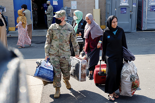 U.S. Army soldiers at the Dulles Expo Center in Chantilly, Va., assist Afghanistan families as they depart an evacuees' processing center Aug. 25, 2021. Catholic organizations are applauding the Jan. 19, 2023, announcement of a new State Department program called the Welcome Corps that allows groups of private individuals to directly support refugees resettling in the U.S. (OSV News photo/Jonathan Ernst, Reuters)