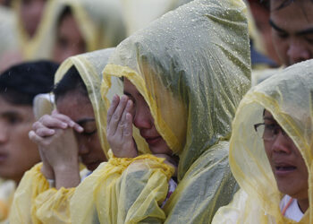 Pilgrims react during a moment of silence for victims of Typhoon Haiyan in 2013 as Pope Francis celebrates Mass adjacent to the airport in Tacloban, Philippines, Jan. 17. (CNS photo/Paul Haring) See POPE-TACLOBAN Jan. 17, 2015.
