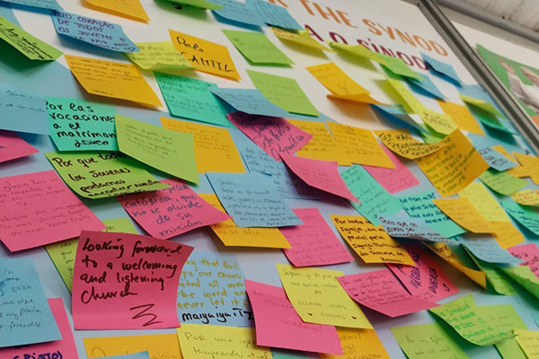 Dozens of Post-it Notes with prayers and requests from young people are seen on the wall at the Synod of Bishops' booth in a park in Lisbon, Portugal, during World Youth Day Aug. 1-6, 2023. (OSV News photo/Courtesy of the Synod Secretariat)