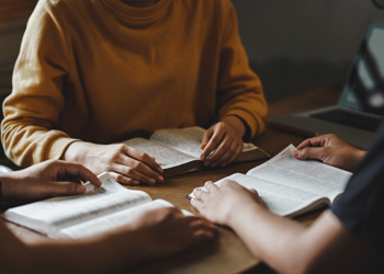 Christian couple or group reading study the bible together and pray at a home or Sunday school at church. concept studying the word of god.