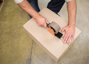 Close up of warehouse worker preparing a shipment in a large warehouse