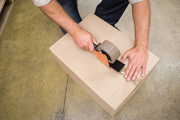 Close up of warehouse worker preparing a shipment in a large warehouse