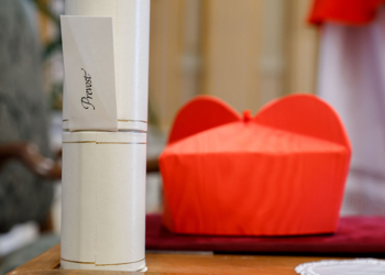 Chicago-born Cardinal Robert F. Prevost’s red biretta and scroll, are seen next to his chair as he greets well-wishers in the Apostolic Palace at the Vatican after a consistory where Pope Francis made him and 20 other prelates cardinals Sept. 30, 2023. (CNS photo/Lola Gomez)