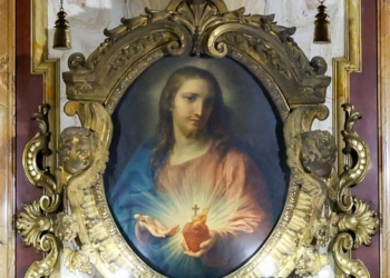 A painting of the Sacred Heart of Jesus is displayed in an ornate frame inside the Jesuit Church of the Gesù in Rome, Oct. 22, 2024. The Latin inscription at the bottom reads “Adveniat Regnum Tuum,” meaning “Thy Kingdom Come.” (CNS photo/Lola Gomez)