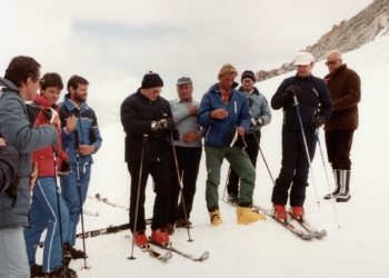 Pope John Paul II (center, in red boots) prays with a group of skiers before heading down a slope in this 1984 file photo. The pontiff, who enjoyed skiing in his native Poland before his election, was able to slip away to ski only a few times as he led the worldwide church. (OSV News photo/Arturo Mari, Vatican)