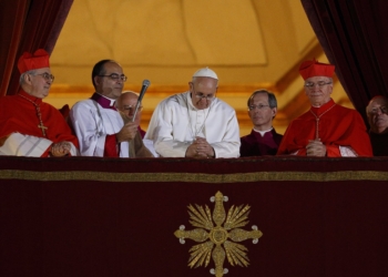 Pope Francis bows his head in prayer during his election night appearance on the central balcony of St. Peter's Basilica at the Vatican March 13, 2013. The crowd joined the pope in silent prayer after he asked them to pray that God would bless him. (CNS photo/Paul Haring)