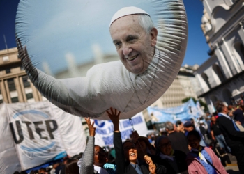 People touch a balloon with a picture of Pope Francis outside the Buenos Aires Metropolitan Cathedral, following the death of the pontiff, in Buenos Aires, Argentina, April 26, 2025. REUTERS/Agustin Marcarian