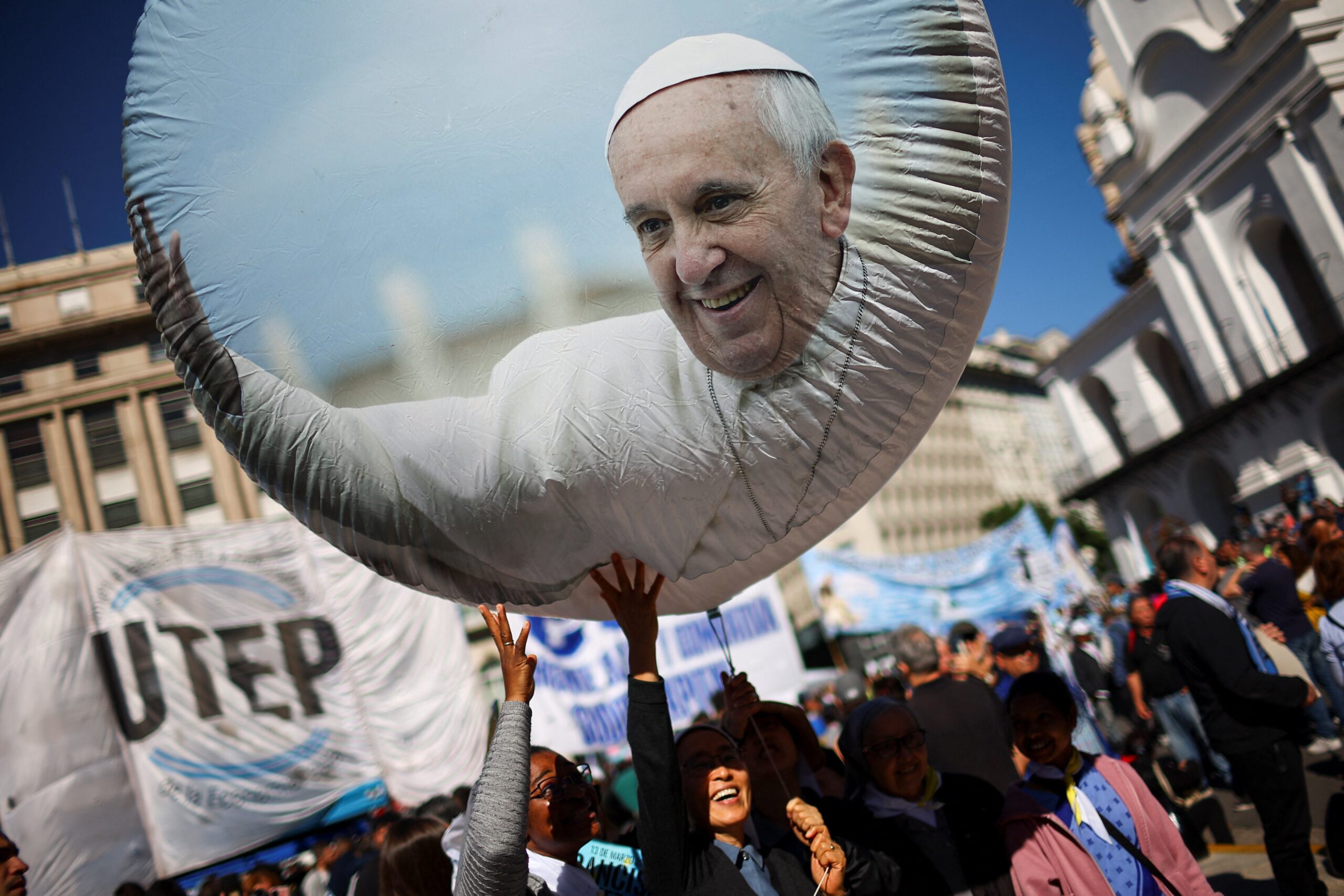 People touch a balloon with a picture of Pope Francis outside the Buenos Aires Metropolitan Cathedral, following the death of the pontiff, in Buenos Aires, Argentina, April 26, 2025. REUTERS/Agustin Marcarian