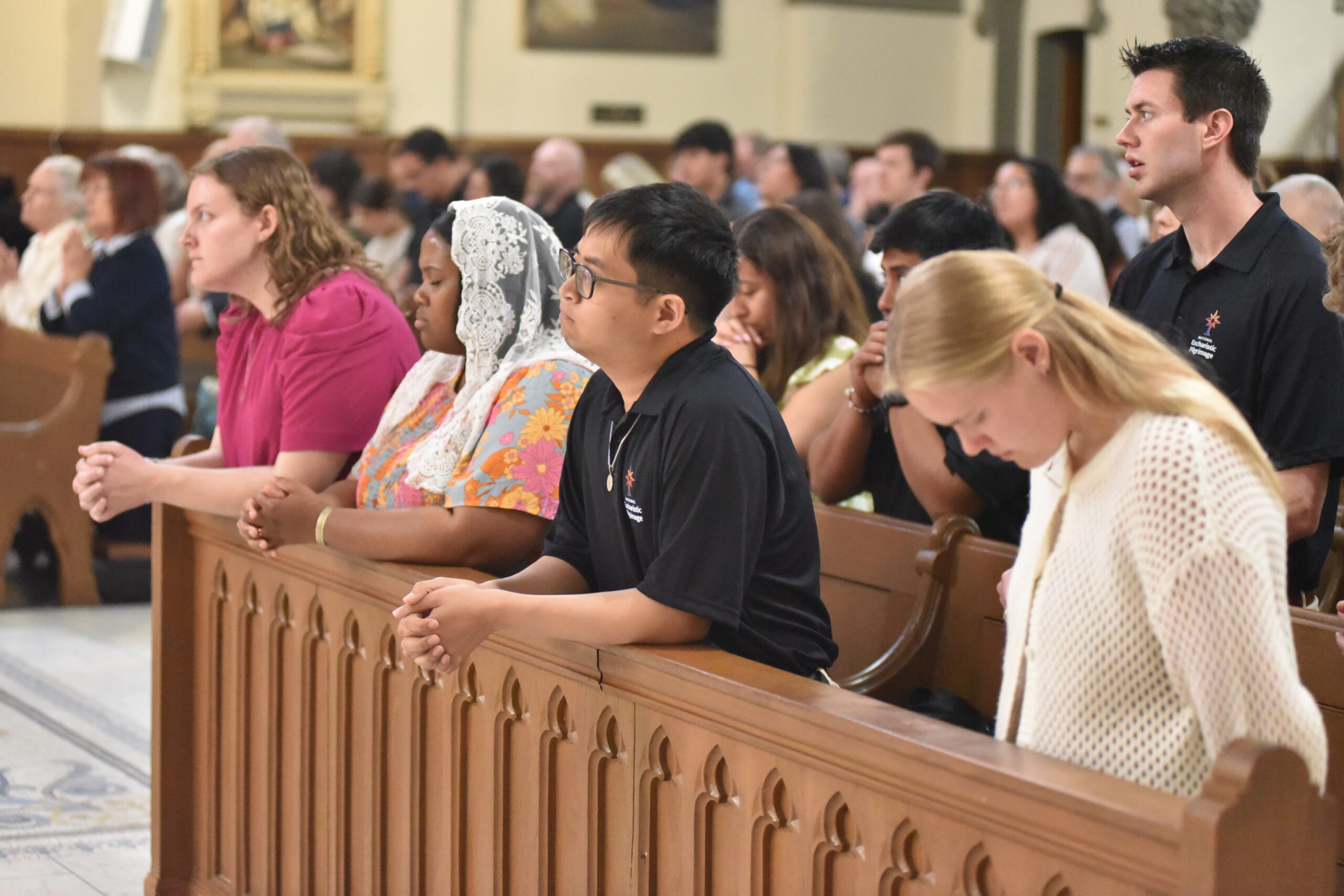 in the National Eucharistic Pilgrimage kneel in prayer on May 18, 2025, during a Mass at St. John the Evangelist Church in Indianapolis. The pilgrimage, which will conclude on June 22 in Los Angeles, will travel through 10 states and 20 dioceses in its St. Katherine Drexel Route. (OSV News photo/Sean Gallagher, The Criterion)