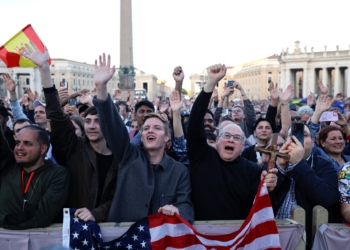 Men holding a U.S. flag cheer as Cardinal Robert Francis Prevost, who has chosen the papal name Leo XIV, appears on the central balcony of St. Peter's Basilica at the Vatican May 8, 2025, following his election during the conclave. He is the first American pope in history. (OSV News photo/Amanda Perobelli, Reuters)