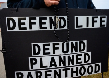 A pro-lifer holds a rosary and sign in this file photo from Nov. 3, 2019. Planned Parenthood released its new annual report for 2023-2024, their first covering a period of time after the Dobbs decision. (OSV News photo/Sam Lucero, The Compass)