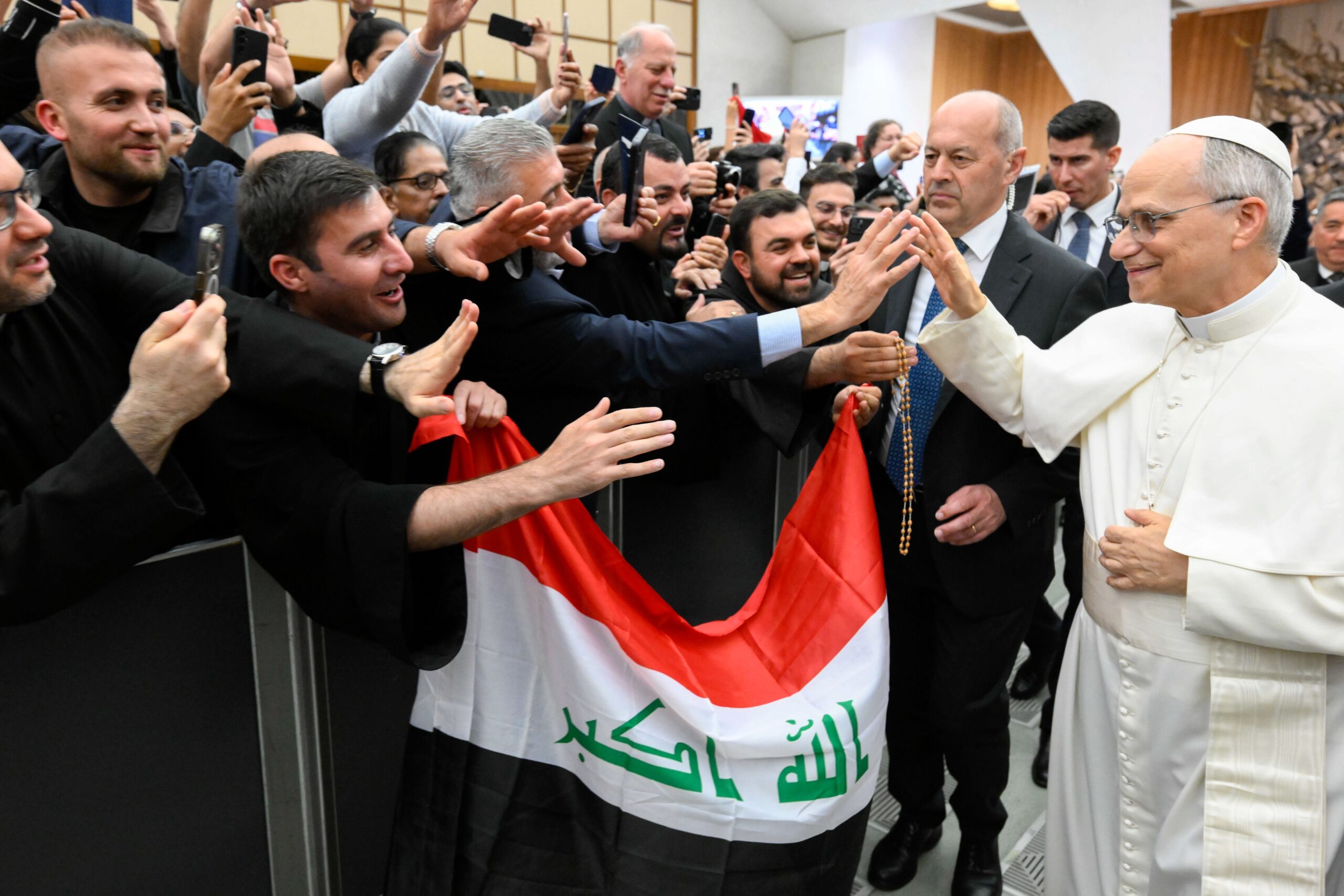 Pope Leo XIV greets participants holding an Iraqi flag as he walks through the Paul VI Audience Hall at the Vatican during the Jubilee of the Eastern Churches May 14, 2025. (CNS photo/Lola Gomez)