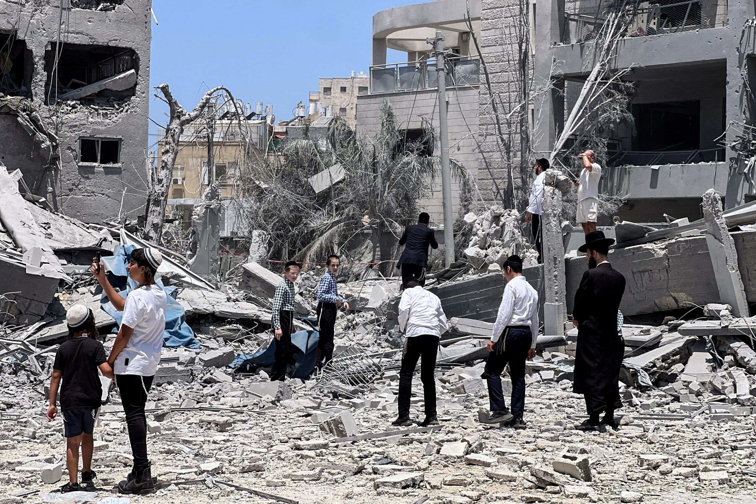 Ultra Orthodox jews look at an impacted site in Tel Aviv, Israel, June 16, 2025, following a missile attack from Iran. Iran fired a new wave of missile attacks on Israel early June 16, killing several people, while Israel warned residents of part of Tehran to evacuate ahead of new strikes.  (OSV News photo/Miro Maman, Reuters)