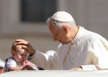 Pope Leo XIV greets a child from the popemobile as he rides around St. Peter's Square at the Vatican before his weekly general audience June 4, 2025. (CNS photo/Lola Gomez)