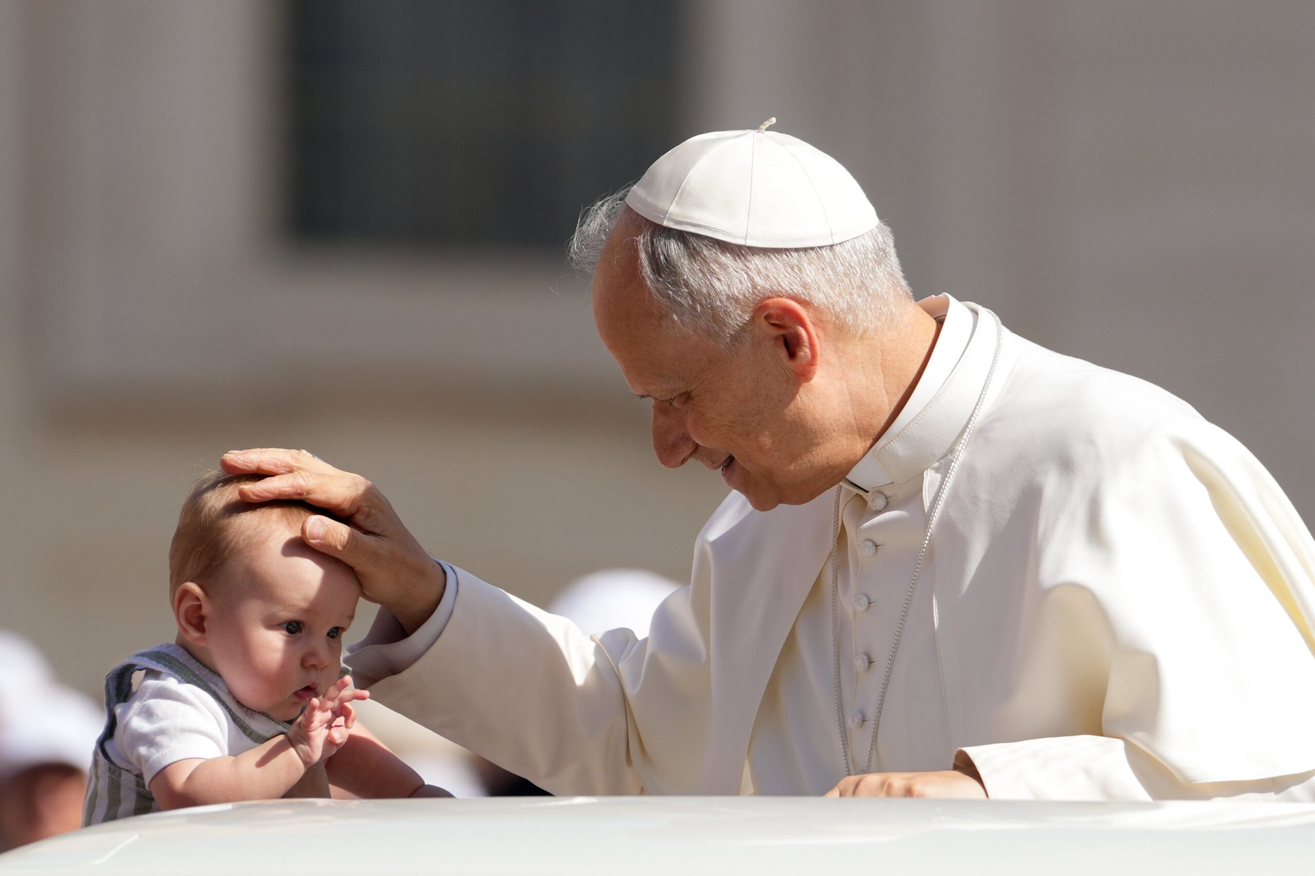Pope Leo XIV greets a child from the popemobile as he rides around St. Peter's Square at the Vatican before his weekly general audience June 4, 2025. (CNS photo/Lola Gomez)