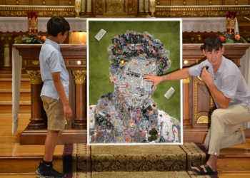 Denver-based multimedia artist Johnny Vrba is pictured inside St. Hedwig Church in Chicago July 23, 2025,  explaining the significance of a section of the Blessed Carlo Acutis mosaic he created for a Chicago parish bearing the soon-to-be-saint’s name, to answer a boy’s questions about the mosaic. The portrait made up of more than 1,000 toy figurines includes numerous aspects of the teenager’s life, along with biblical references and the 163 Eucharistic miracles that Blessed Acutis documented. (OSV News photo/Simone Orendain)