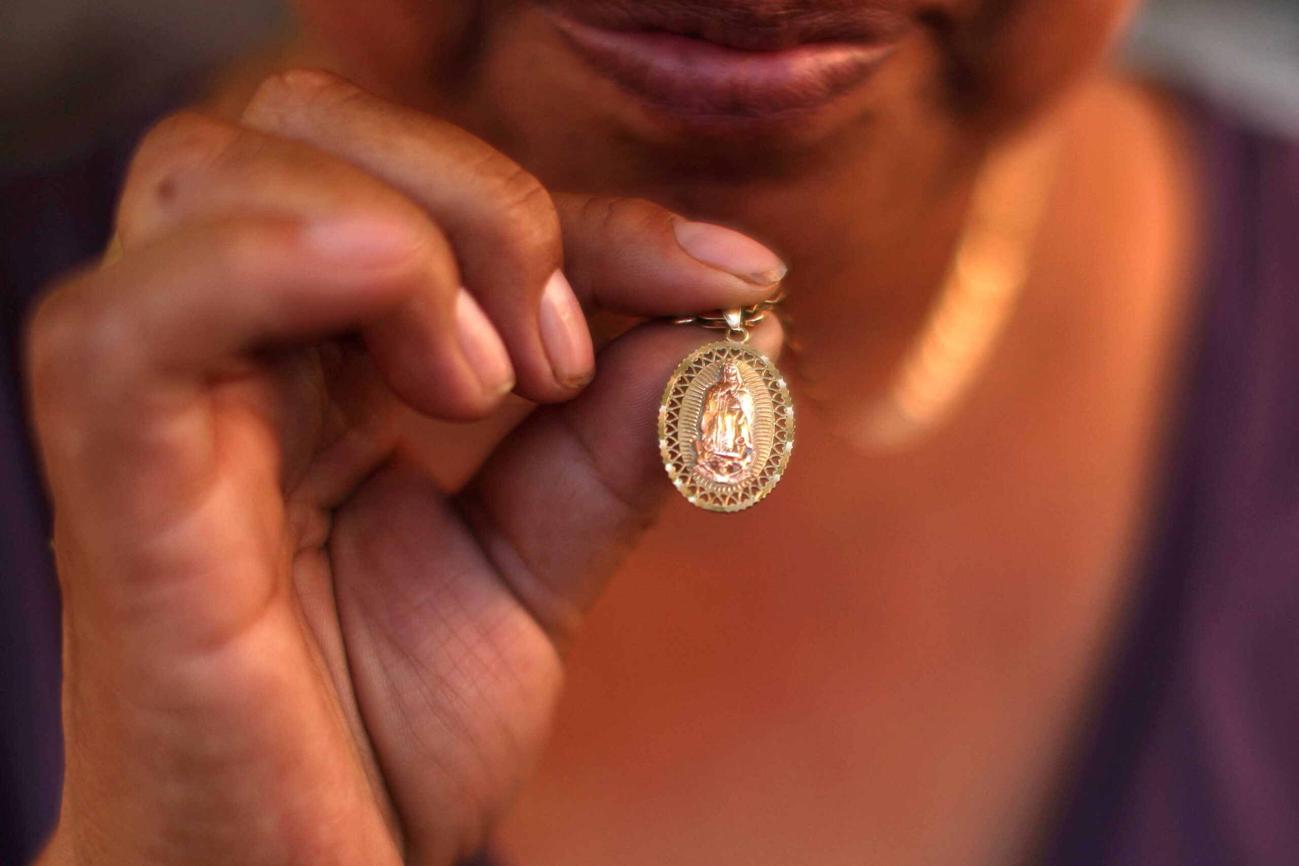 A Guatemalan woman shows her Our Lady of Guadalupe medal in Los Angeles, June 16, 2025, that she has been keeping since the immigration sweeps began. Bishop Alberto Rojas of San Bernardino, Calif., announced July 9 that he has dispensed his diocese from the obligation to attend Sunday Mass due to ongoing ICE raids. (OSV News photo/Pilar Olivares, Reuters)
