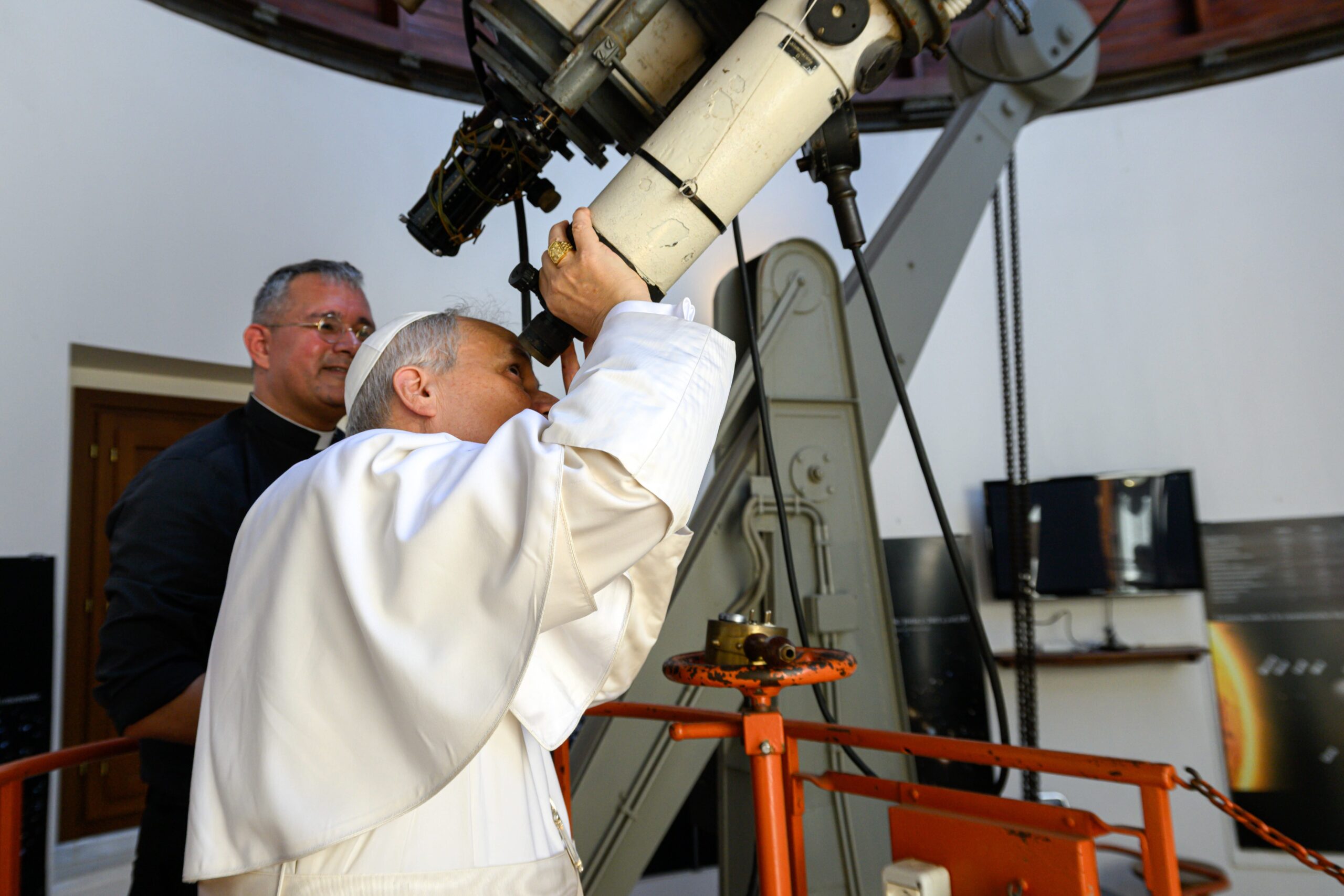 Pope Leo XIV looks through the main telescope of the Vatican Observatory in Castel Gandolfo, Italy, alongside U.S. Jesuit Father David A. Brown, an astronomer, July 20, 2025. The pope visited the observatory to mark the anniversary of the first crewed mission to land on the moon in 1969, following the recitation of the Angelus in the city’s main square. (CNS photo/Vatican Media)