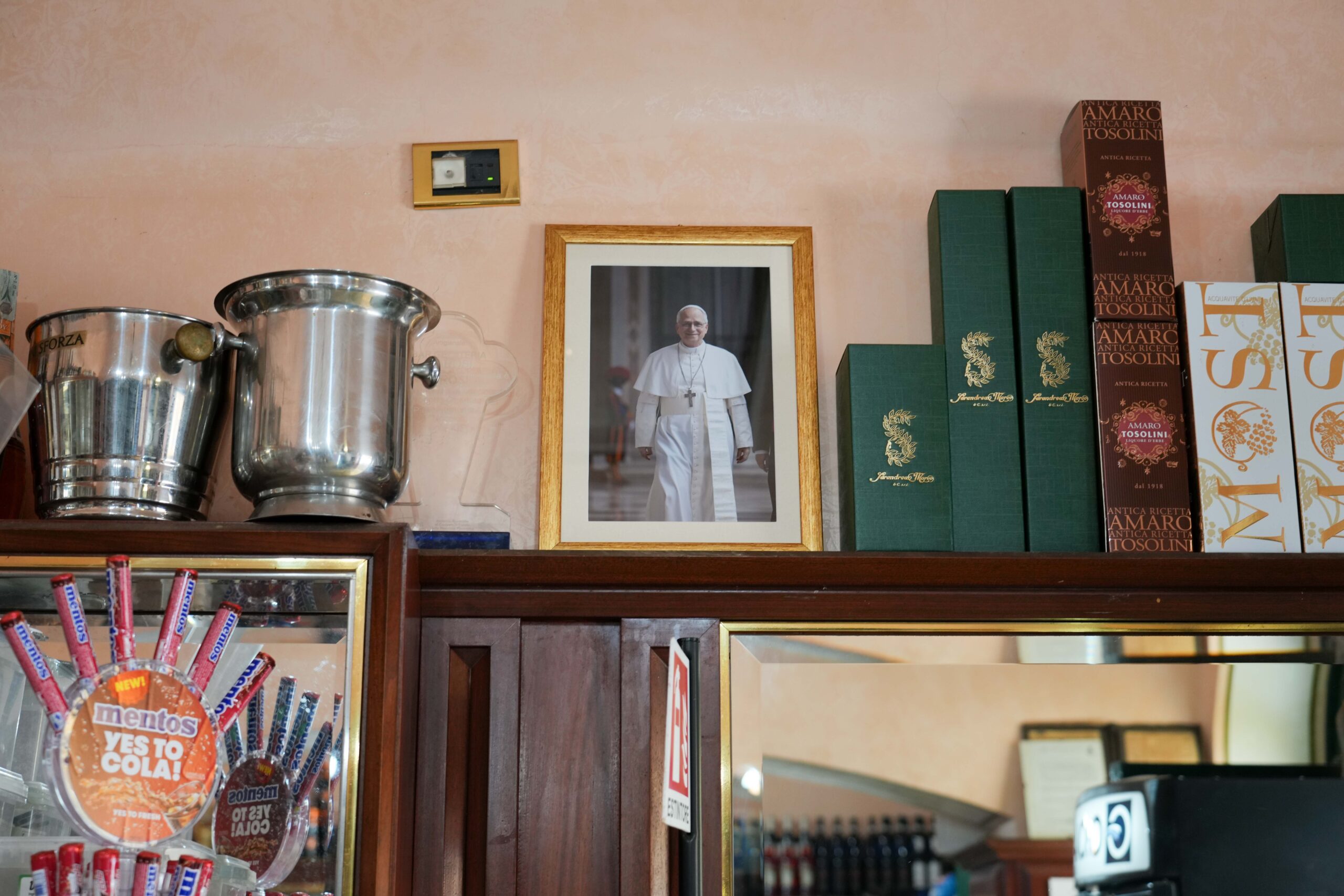 A framed photo of Pope Leo XIV is displayed inside a local café on the main square of Castel Gandolfo, Italy, July 1, 2025, as the town prepares for the pope’s first official visit for his customary July retreat. (CNS photo/Lola Gomez)