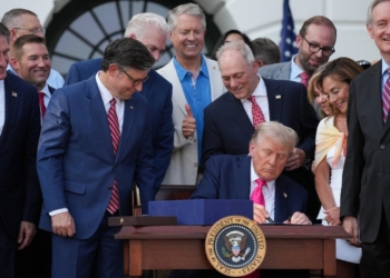 U.S. House of Representatives Speaker Mike Johnson looks at U.S. President Donald Trump signing the sweeping spending and tax legislation, known as the "One Big Beautiful Bill Act," to mark Independence Day, at the White House in Washington, D.C., U.S., July 4, 2025. REUTERS/Leah Millis