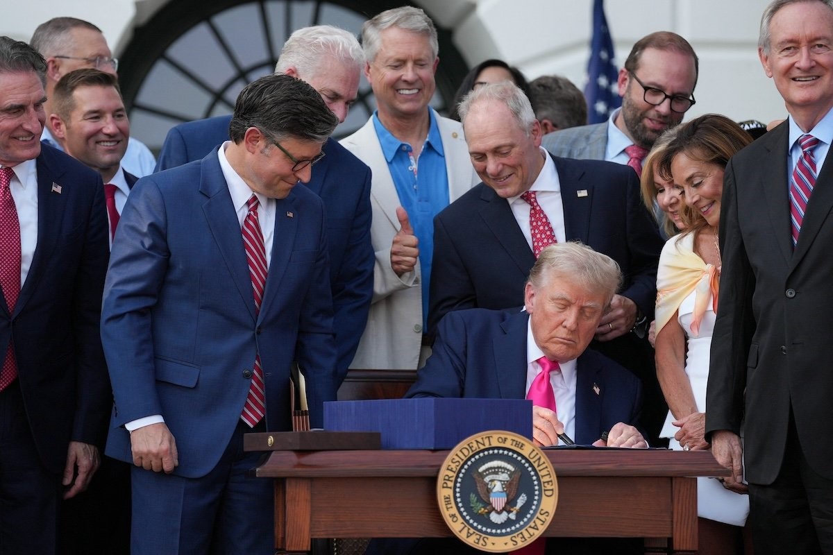 U.S. House of Representatives Speaker Mike Johnson looks at U.S. President Donald Trump signing the sweeping spending and tax legislation, known as the "One Big Beautiful Bill Act," to mark Independence Day, at the White House in Washington, D.C., U.S., July 4, 2025. REUTERS/Leah Millis