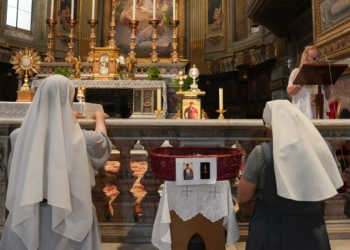 Religious sisters pray before the relics of Blessed Carlo Acutis at the Church of San Marcello al Corso in Rome July 31, 2025. (CNS photo/Lola Gomez)