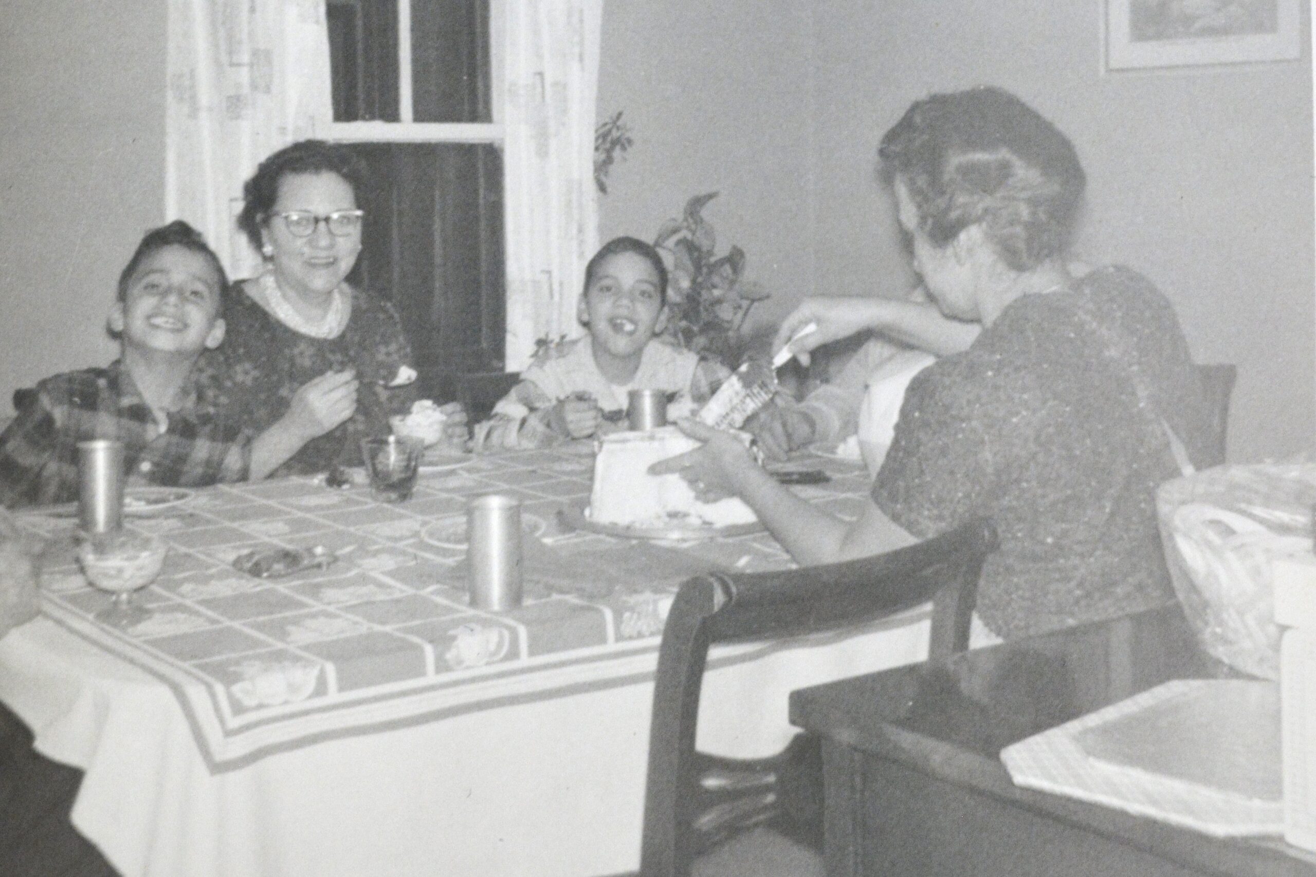 In this undated photo, Pope Leo XIV (then Robert Prevost) (left) smiles while his mother (back to the camera) cuts a birthday cake in what his brother (right) guessed was the pope's 9th birthday, at the family home in the Chicago suburb of Dolton.  (OSV News photo/Prevost family)
