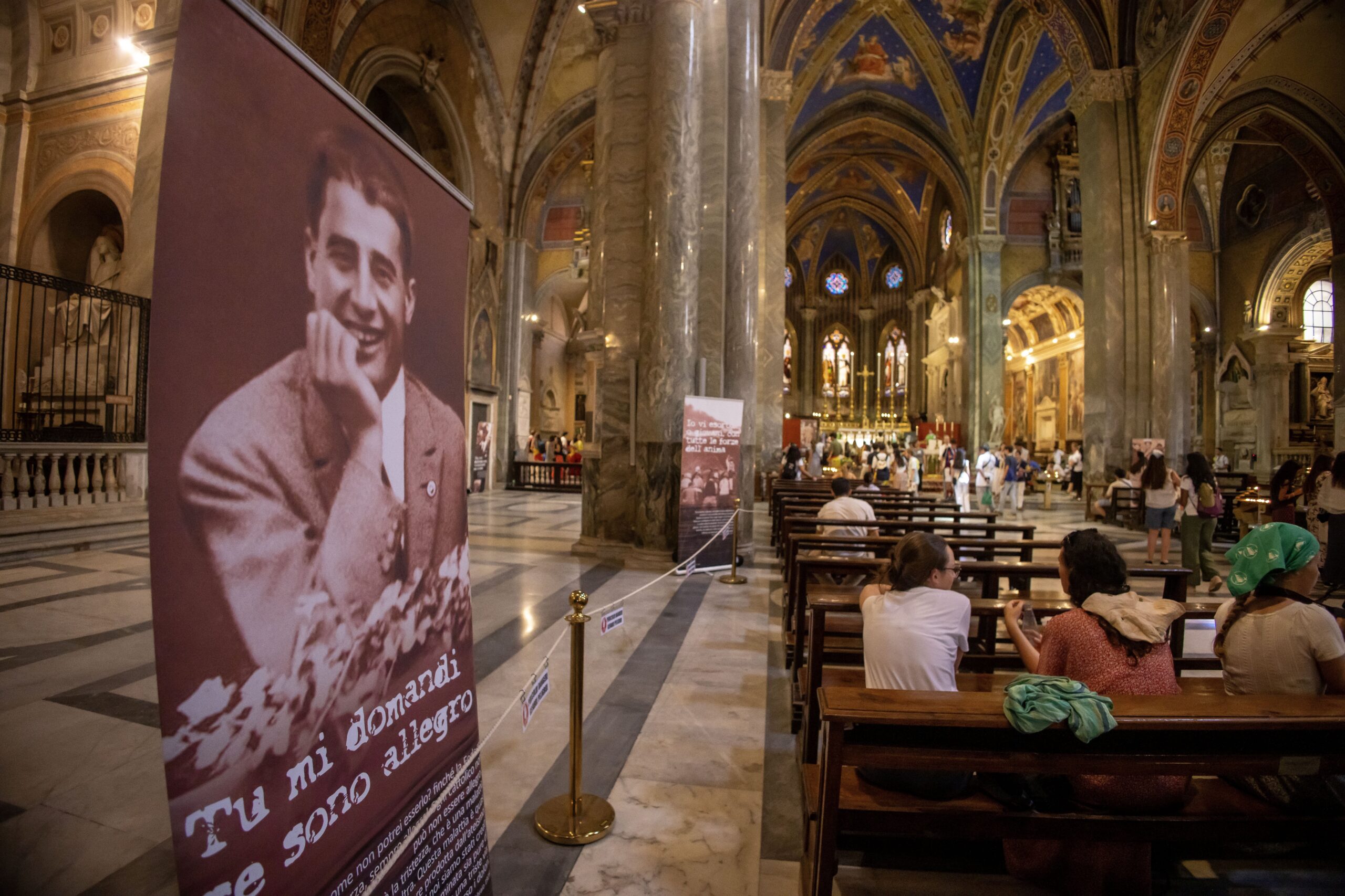 Pilgrims visit the Basilica of Santa Maria sopra Minerva in Rome July 31, 2025, where the relics of Blessed Pier Giorgio Frassati have been brought for the Jubilee of Youth. Banners inside the basilica feature images and quotes from the blessed, whose casket containing his remains were brought from his tomb in Turin for veneration. (CNS photo/Pablo Esparza)