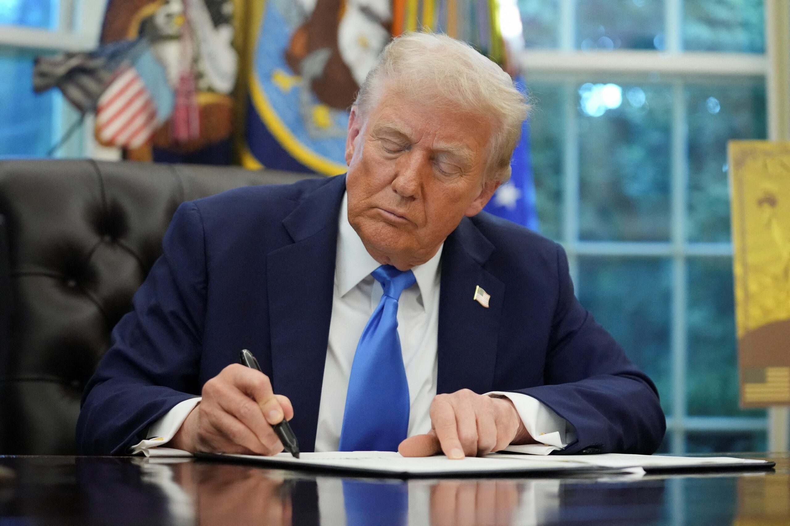 U.S. President Donald Trump signs an executive order in the Oval Office at the White House in Washington Sept. 19, 2025. Trump signed two executive orders, establishing the “Trump Gold Card” and introducing a $100,000 fee for H-1B visas. (OSV News photo/Ken Cedeno, Reuters)