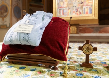 A cross containing blood-stained dirt from the site in the Amazon where Notre Dame de Namur Sister Dorothy Stang was killed in 2005, along with one of her sweaters, sits on the main altar before a prayer service at the Church of St. Bartholomew on Tiber Island in Rome Jan. 10, 2025. (CNS photo/Lola Gomez)