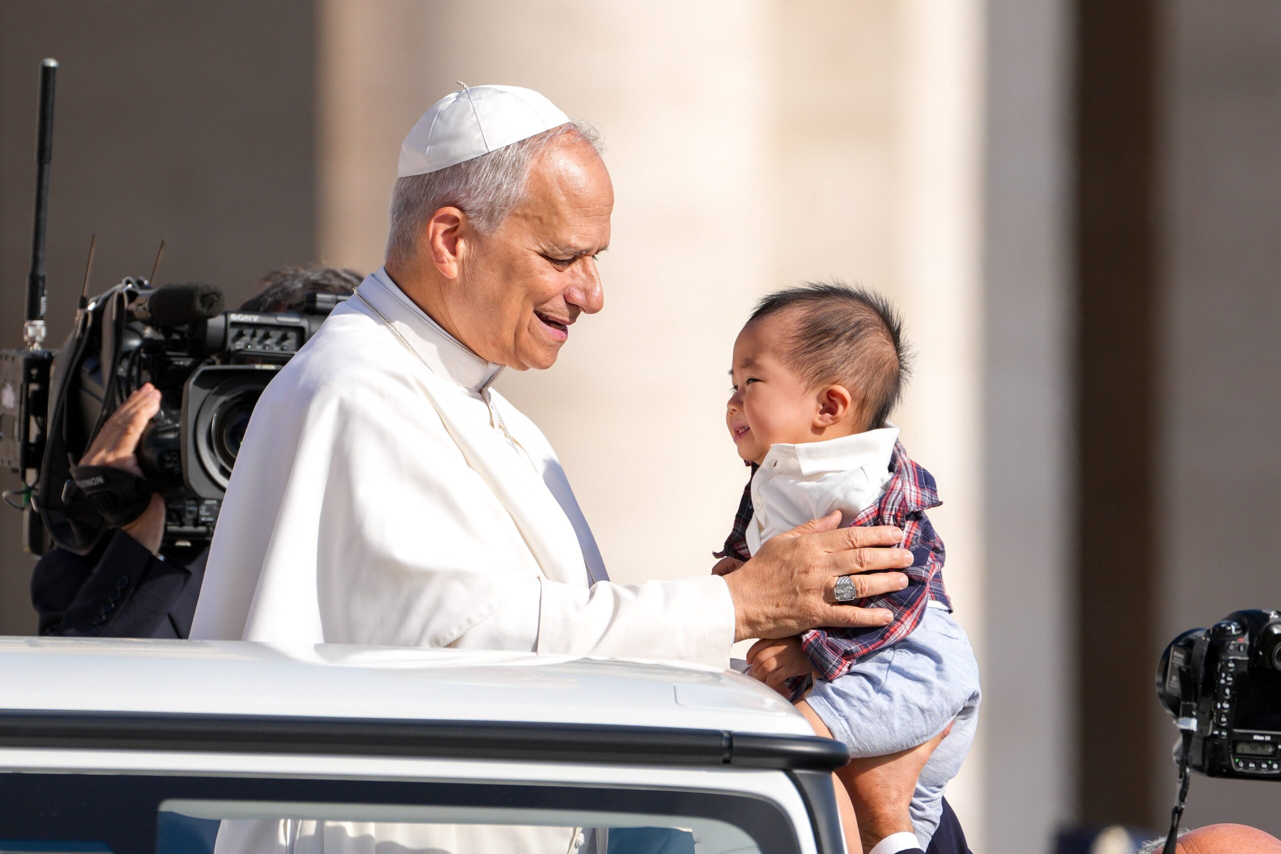Pope Leo XIV greets a child from the popemobile as he rides around St. Peter's Square at the Vatican before his weekly general audience Sept. 17, 2025. (CNS photo/Lola Gomez)