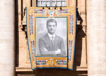 A banner with the image of St. Pier Giorgio Frassati hangs from the facade of St. Peter’s Basilica during his canonization Mass at the Vatican Sept. 7, 2025. (CNS photo/Lola Gomez)