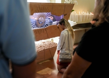 A woman kneels in prayer at the tomb of Blessed Carlo Acutis in the Sanctuary of the Renunciation in Assisi, Italy, Aug. 21, 2025. Acutis, who died in 2006 at age 15, will be canonized Sept. 7 at the Vatican by Pope Leo XIV. (CNS photo/Lola Gomez)