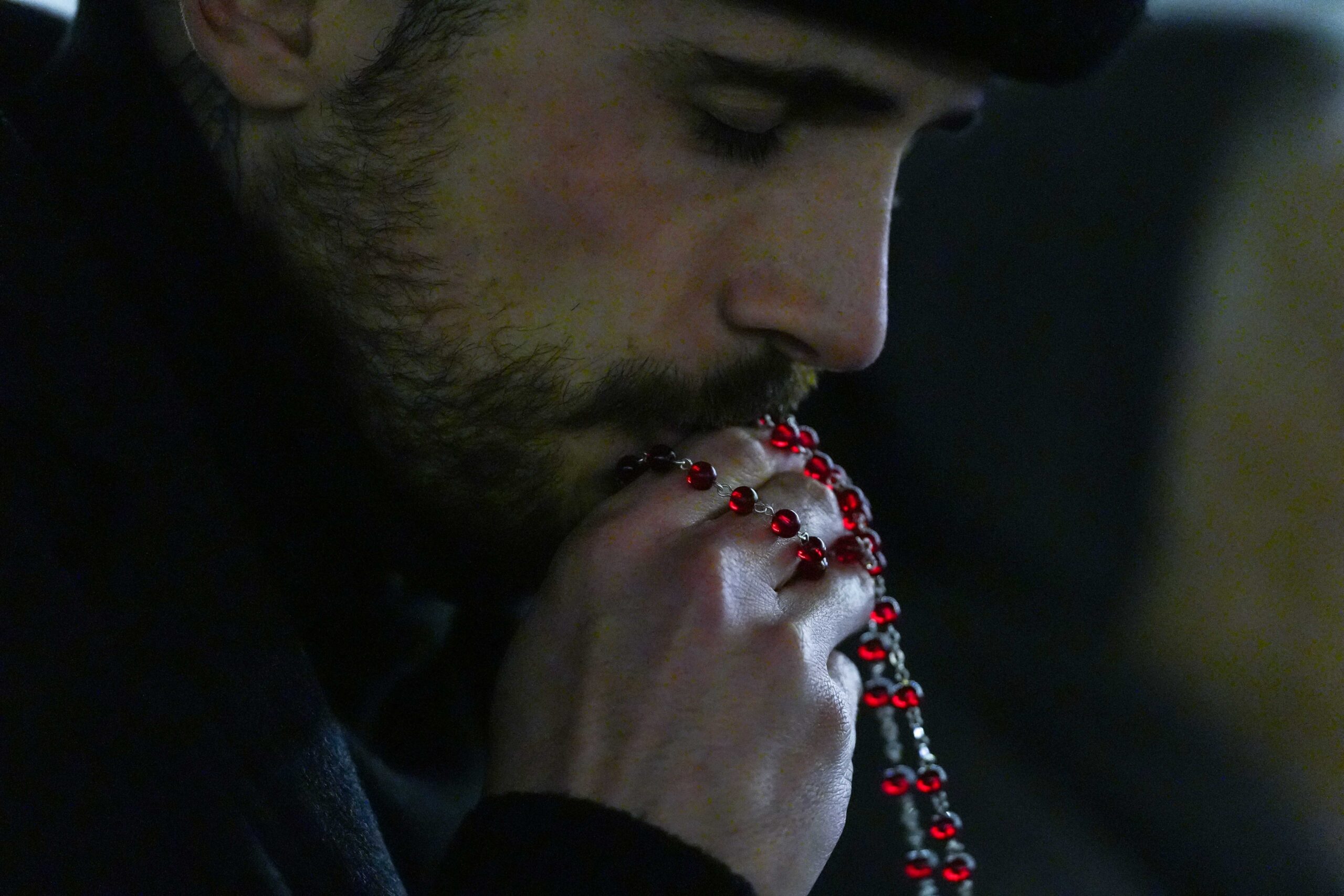 A man kisses a rosary as he joins hundreds of people praying in St. Peter’s Square at the Vatican in this file photo from Feb. 25, 2025. (CNS photo/Lola Gomez)