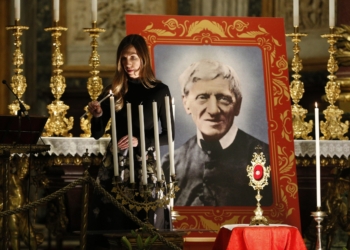 Melissa Villalobos of Chicago lights a candle during a vigil in advance of the canonization of St. John Henry Newman, at the Basilica of St. Mary Major in Rome Oct. 12, 2019. Villalobos' healing through the intercession of St. John Henry Newman was accepted as the miracle needed for the British cardinal's canonization.  (CNS photo/Paul Haring) See SAINTS-NEWMAN-VIGIL to come.