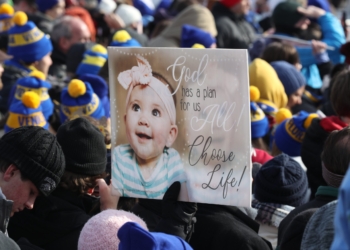 An attendee holds a poster during the 52nd annual March for Life rally in Washington Jan. 24, 2025. (OSV News photo/Bob Roller).