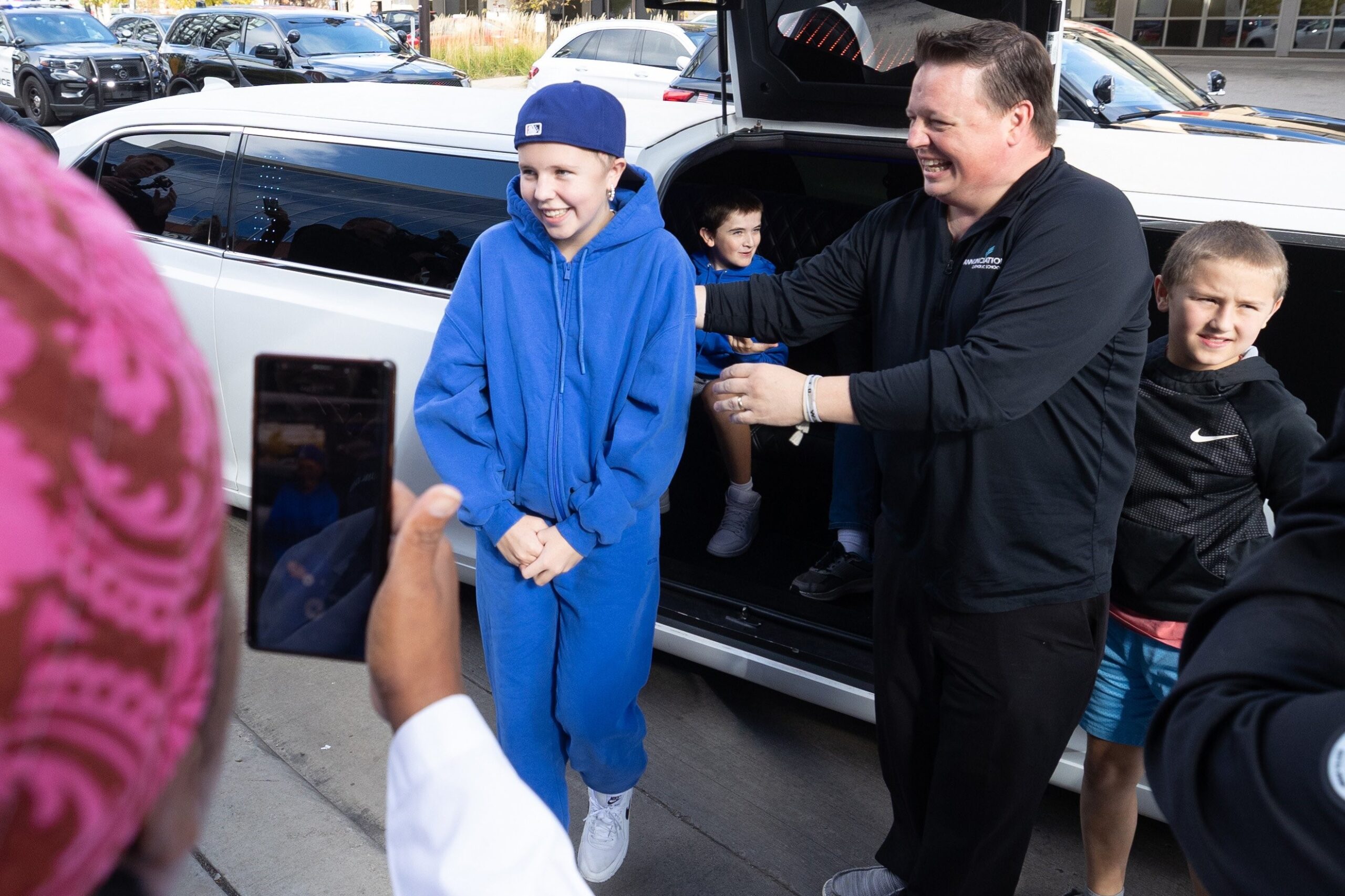 Sophia Forchas and her father, Tom Forchas, exit a limousine at Hennepin County Medical Center in downtown Minneapolis Oct. 23, 2025, just after her release from Gillette Children’s Hospital in St. Paul. A police escort led by Minneapolis Police Chief Brian O’Hara arrived at HCMC for a brief visit with hospital staff there who treated Forchas after she was hit during the Aug. 27 shooting at Annunciation church in Minneapolis. (OSV News photo/Dave Hrbacek, The Catholic Spirit)