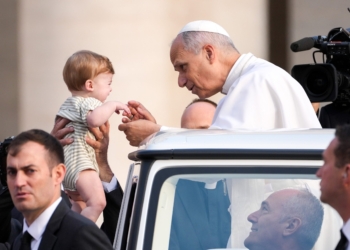 Pope Leo XIV greets a child from the popemobile as he rides around St. Peter's Square at the Vatican before his weekly general audience Oct. 15, 2025. (CNS photo/Lola Gomez)