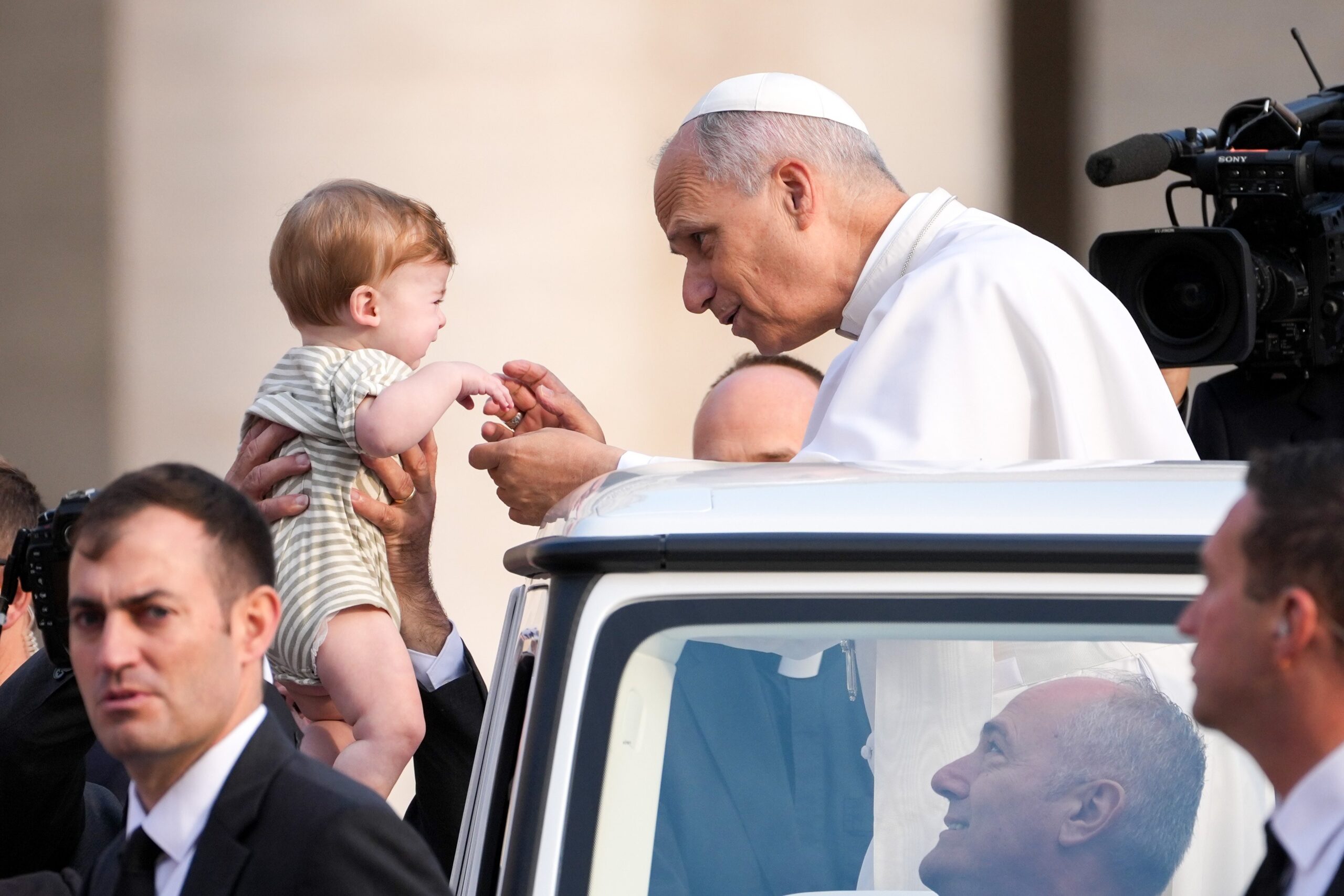 Pope Leo XIV greets a child from the popemobile as he rides around St. Peter's Square at the Vatican before his weekly general audience Oct. 15, 2025. (CNS photo/Lola Gomez)