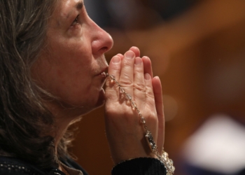 A woman becomes emotional as she prays with a rosary during Eucharistic adoration following the opening Mass of the National Prayer Vigil for Life Jan. 19, 2023, at the Basilica of the National Shrine of the Immaculate Conception in Washington. (OSV News photo/Bob Roller)