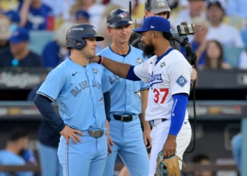 Los Angeles Dodgers right fielder Teoscar Hernandez (37) and Toronto Blue Jays center fielder Daulton Varsho (5) talk as first base coach Mark Budzinski (53) looks on during a challenge on a play in the first inning during game five of the 2025 MLB World Series at Dodger Stadium in Los Angeles Oct. 29, 2025. Mandatory Credit: (OSV News photo/Jayne Kamin-Oncea-Imagn Images via Reuters)
