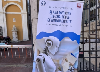 The poster for the international congress, "AI and Medicine: The Challenge of Human Dignity," sponsored by the Pontifical Academy for Life and the International Federation of Catholic Medical Associations, is seen Nov. 10, 2025, outside the Jesuit headquarters in Rome where the congress was being held. (CNS photo/Cindy Wooden)