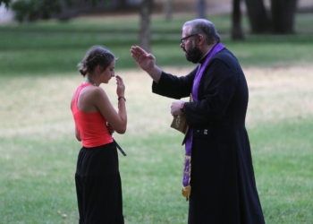 A priest blesses a U.S. pilgrim after hearing her confession during a National Gathering at Quintas das Conchas e dos Lilases Park in Lisbon, Portugal, Aug. 2, 2023. (OSV News photo/Bob Roller)