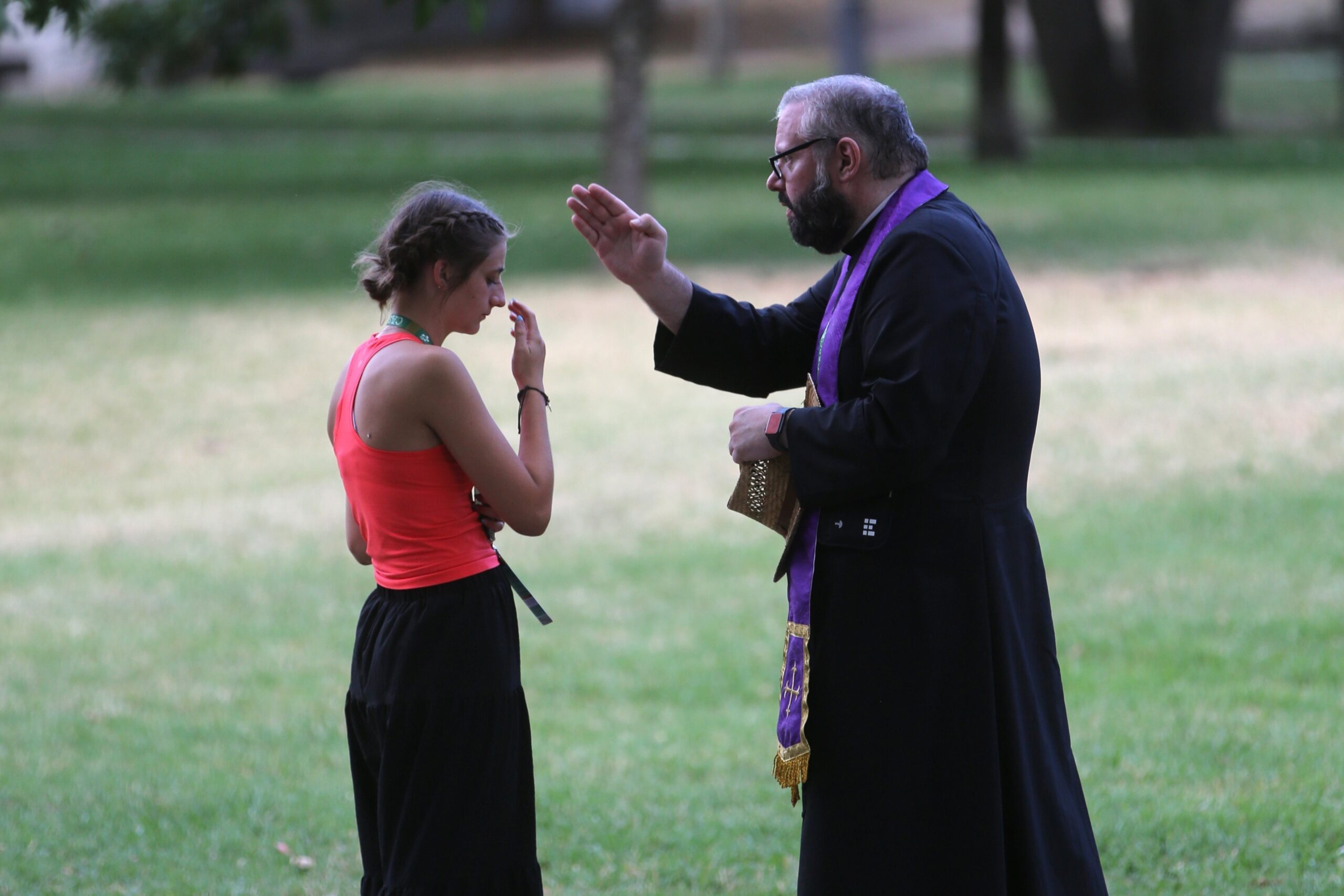 A priest blesses a U.S. pilgrim after hearing her confession during a National Gathering at Quintas das Conchas e dos Lilases Park in Lisbon, Portugal, Aug. 2, 2023. (OSV News photo/Bob Roller)