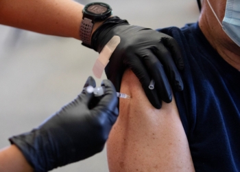 A patient receives a COVID-19 vaccine booster during a Pfizer-BioNTech vaccination clinic in Southfield, Mich., Sept. 29, 2021. The U.S. Catholic bishops have reiterated the moral permissibility of the COVID vaccines available in the United States for Catholics as booster shots become available ahead of flu and cold season. (OSV News photo/Emily Elconin, Reuters)