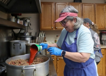 Holy Cross Society of St. Vincent de Paul volunteer Cindy Roames pours tomato sauce into 20 pounds of ground beef to make chili at Good Shepherd Dining Room at Saint Teresa of Avila Church, Parish of the Holy Cross, Bridgeton, Friday, Dec. 5, 2025.