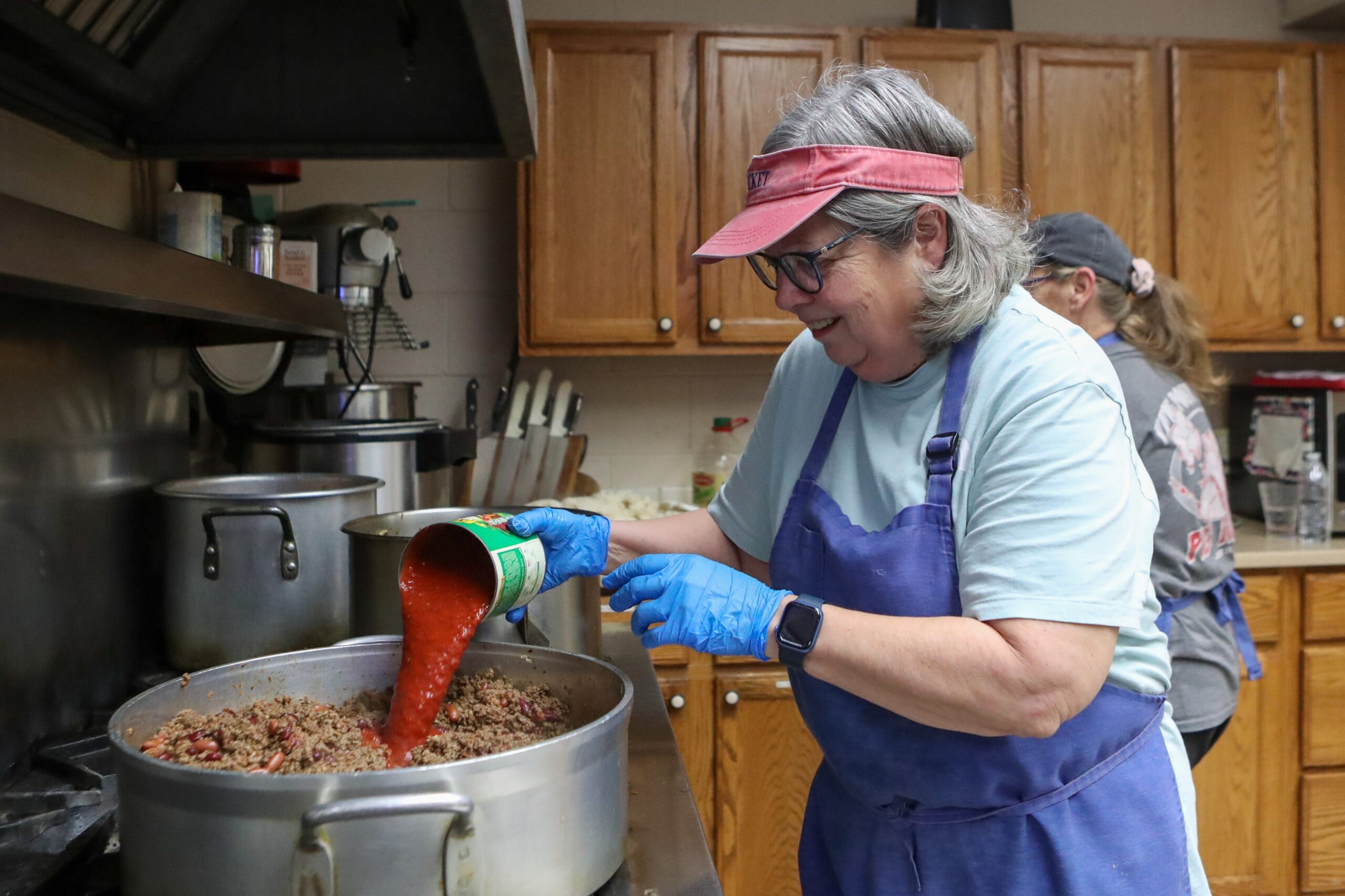 Holy Cross Society of St. Vincent de Paul volunteer Cindy Roames pours tomato sauce into 20 pounds of ground beef to make chili at Good Shepherd Dining Room at Saint Teresa of Avila Church, Parish of the Holy Cross, Bridgeton, Friday, Dec. 5, 2025.