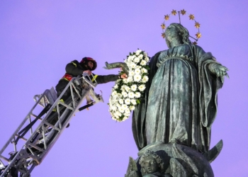 Roberto Leo, a senior firefighter, places a wreath of flowers on a Marian statue near the Spanish Steps in Rome Dec. 8, 2025, the feast of the Immaculate Conception. (CNS photo/Lola Gomez)