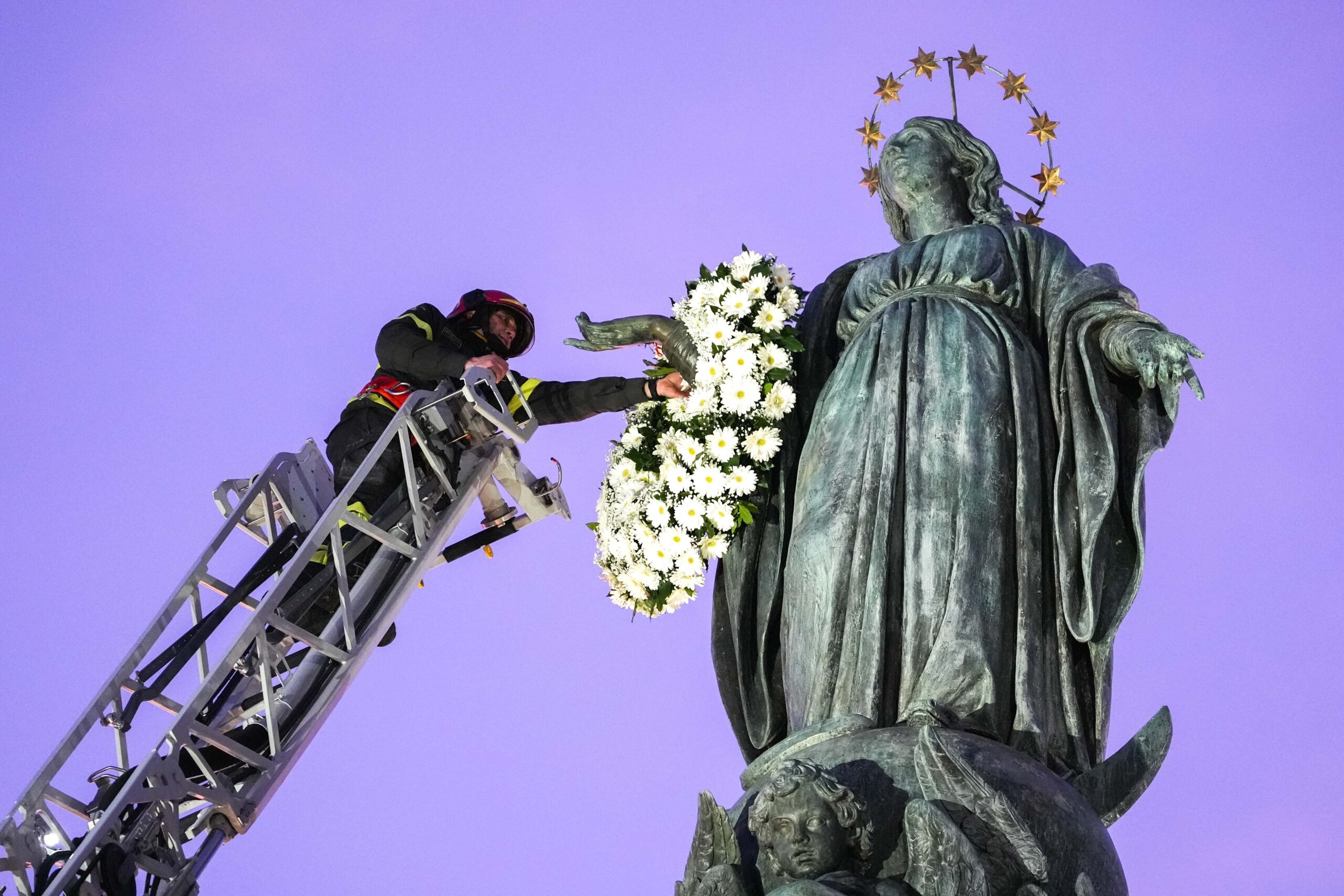 Roberto Leo, a senior firefighter, places a wreath of flowers on a Marian statue near the Spanish Steps in Rome Dec. 8, 2025, the feast of the Immaculate Conception. (CNS photo/Lola Gomez)